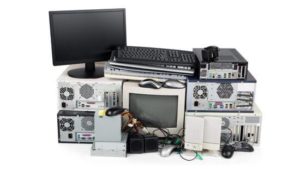 Various items of electronic waste including computers, computer monitors, and computer speakers