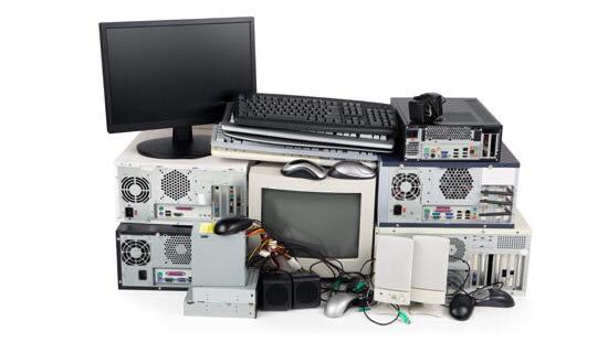 Various items of electronic waste including computers, computer monitors, and computer speakers